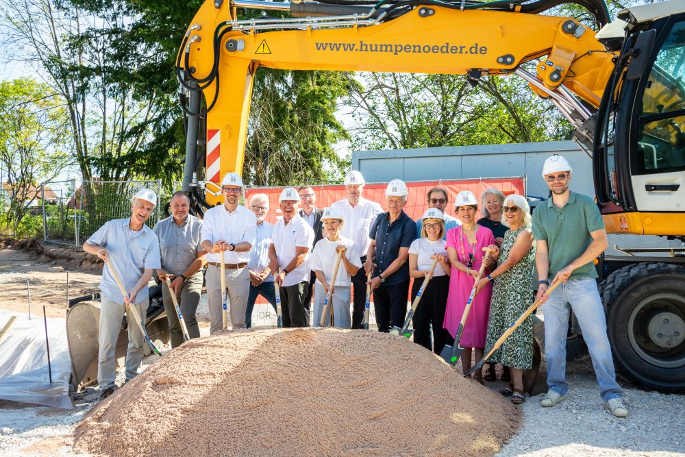 Spatenstich mit Sandhaufen und Bagger